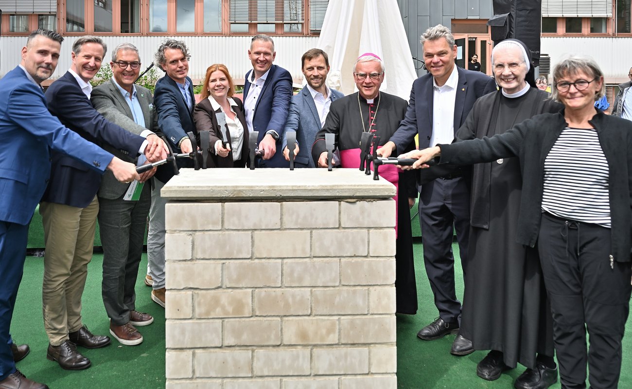Zehn „Hammer-Heldinnen und -helden“ schlagen mit Hämmern symbolisch auf den Grundstein ein, darunter der Klinikgeschäftsführer Florian Kell, der Erzbischof von Berlin Dr. Heiner Koch, der Bezirksbürgermeister von Tempelhof-Schöneberg Jörn Oltmann.