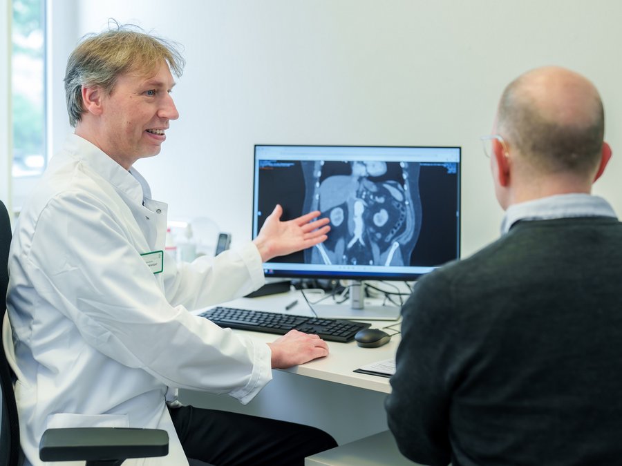 Chefarzt Dr. Linneweber im Gespräch mit einem Patienten.